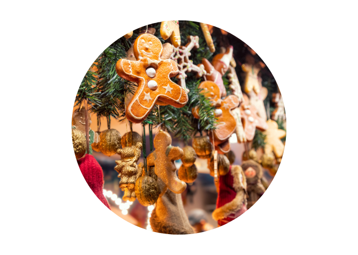 The image shows festive decorations hanging from green foliage. The decorations include little gingerbread characters with white icing and buttons. 